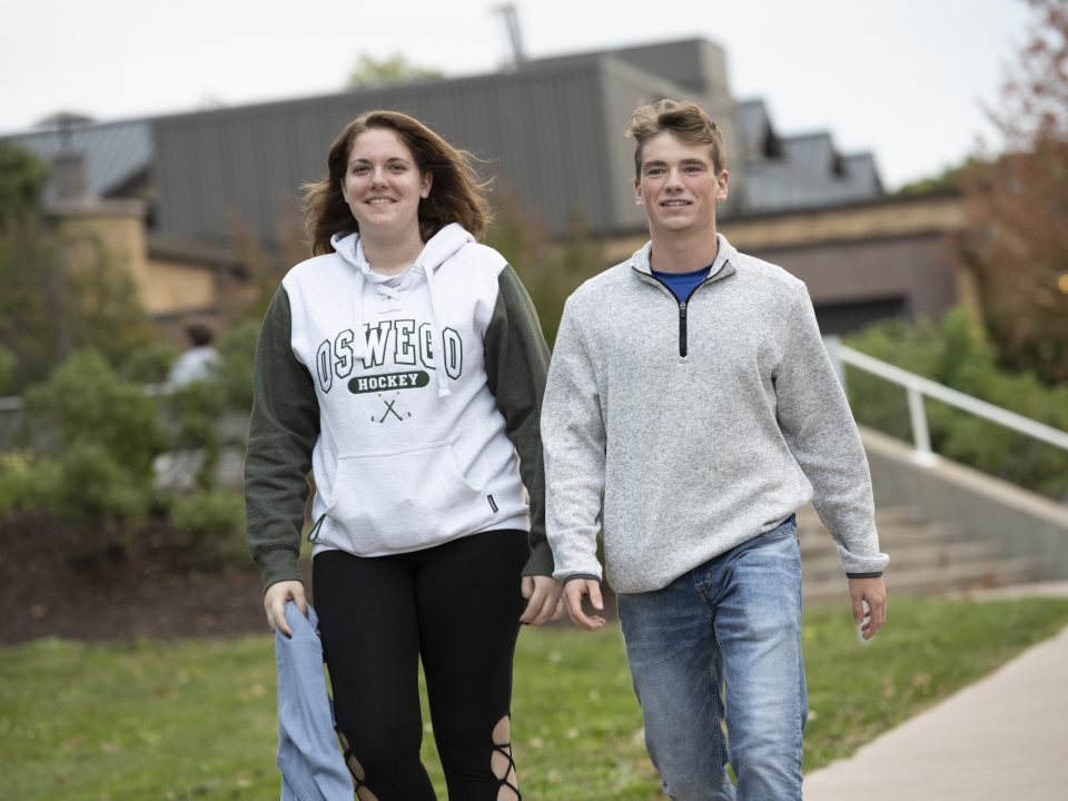Two students waling down a sidewalk on campus