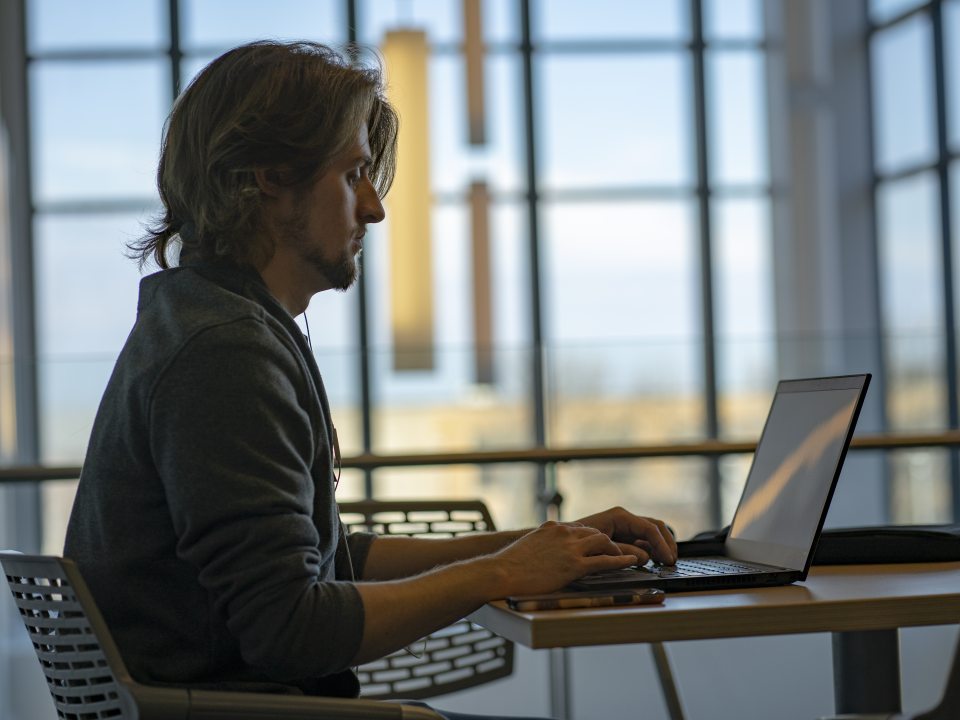 A male student working on a laptop